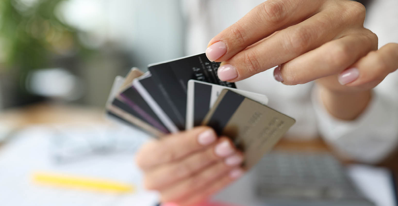 A woman holding a bunch of debit cards like a hand of playing cards. 