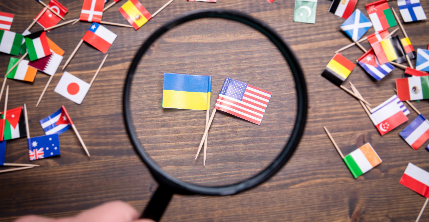 The Ukraine and American flag under a magnifying glass