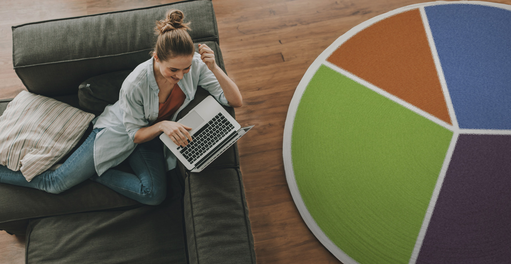 A woman sitting next to a rug that looks like a giant pie chart
