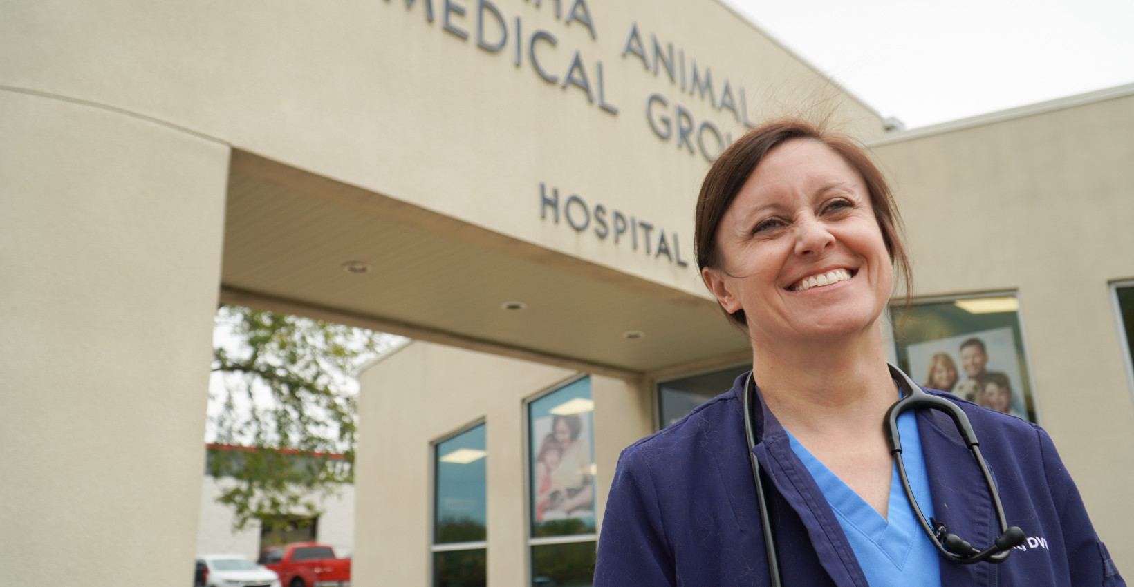 Dr Courtney Knott stands in front of omaha animal medical group building