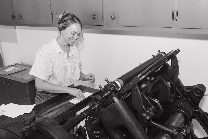 Lindsay Griepenstroh stands at her vintage letter press machine