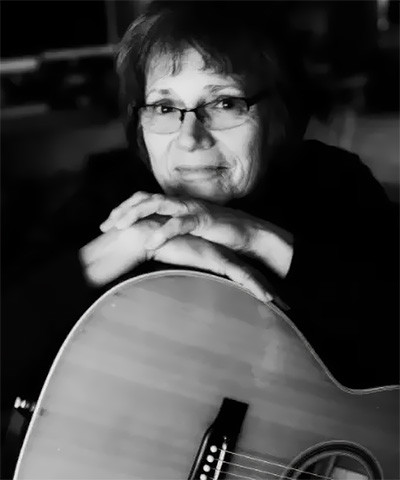 Lynne Faulker leans on a guitar