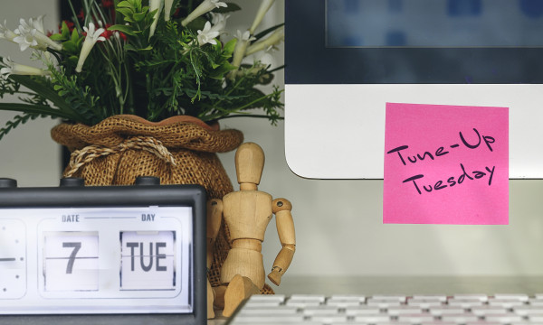A computer with a sticky note on it that says "Tune Up Tuesdays"