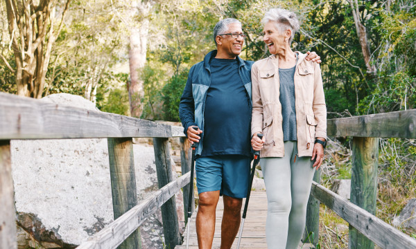 an older couple happily walks together on a bridge