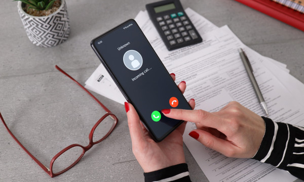 a person holds a phone that is showing an incoming call