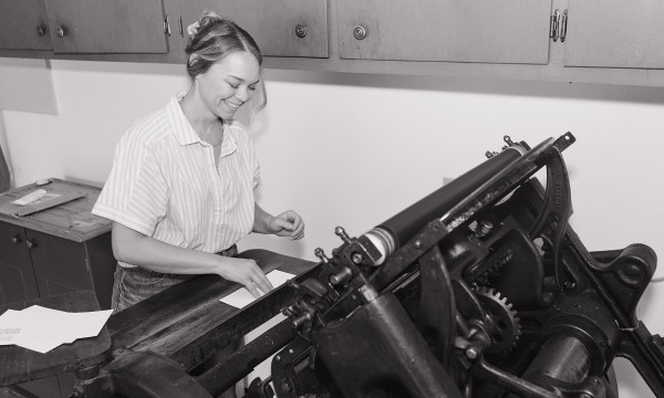 Lindsay Griepenstroh stands at her vintage letter press machine